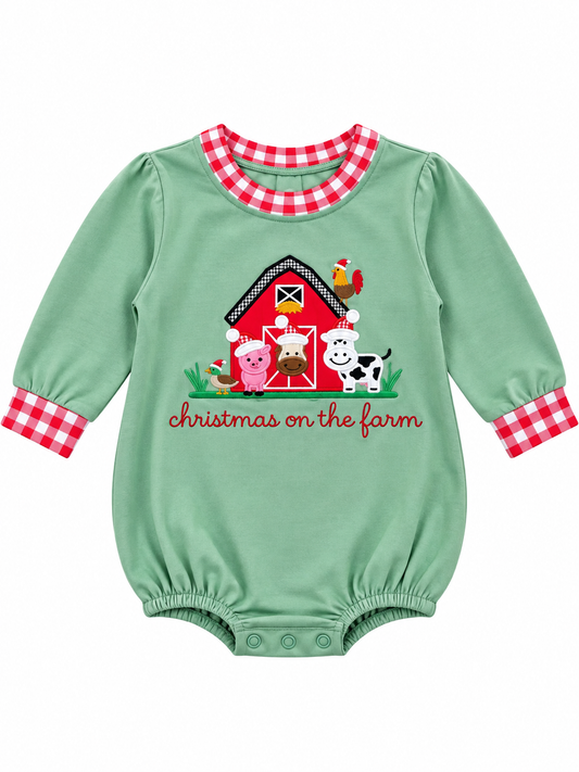 Boys’ sage green Christmas on the Farm bubble romper with long sleeves, red-and-white gingham trim, and a red barn appliqué with farm animals wearing Santa hats.
