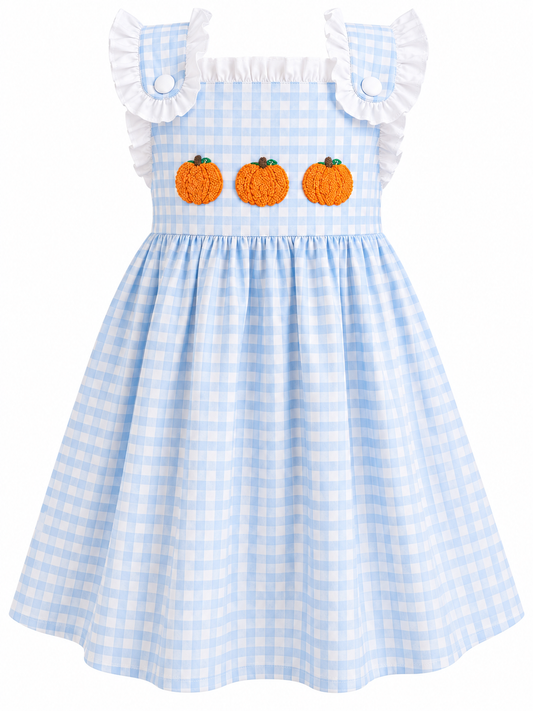 A light blue and white gingham dress for toddlers, featuring ruffled shoulder straps, three orange pumpkin appliques on the chest, and a flared skirt.