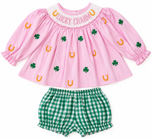 Pink girls’ Lucky Charm outfit with smocked neckline, embroidered green shamrocks and gold horseshoes, paired with green and white gingham bloomers.