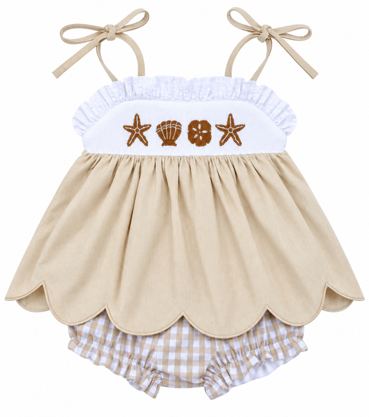 Girls’ beige beach dress with embroidered starfish and seashells, white ruffle bodice, tie straps, scalloped hem, and gingham bloomers.