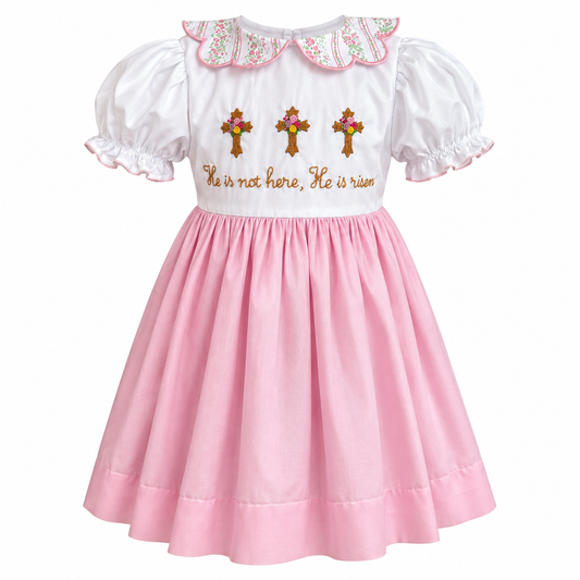 Pink and white girls Easter dress with floral scalloped collar, embroidered crosses, and “He is not here, He is risen” detail.